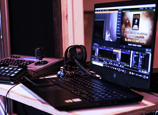 A photo of tech tools and a laptop showing a livestream in progress.