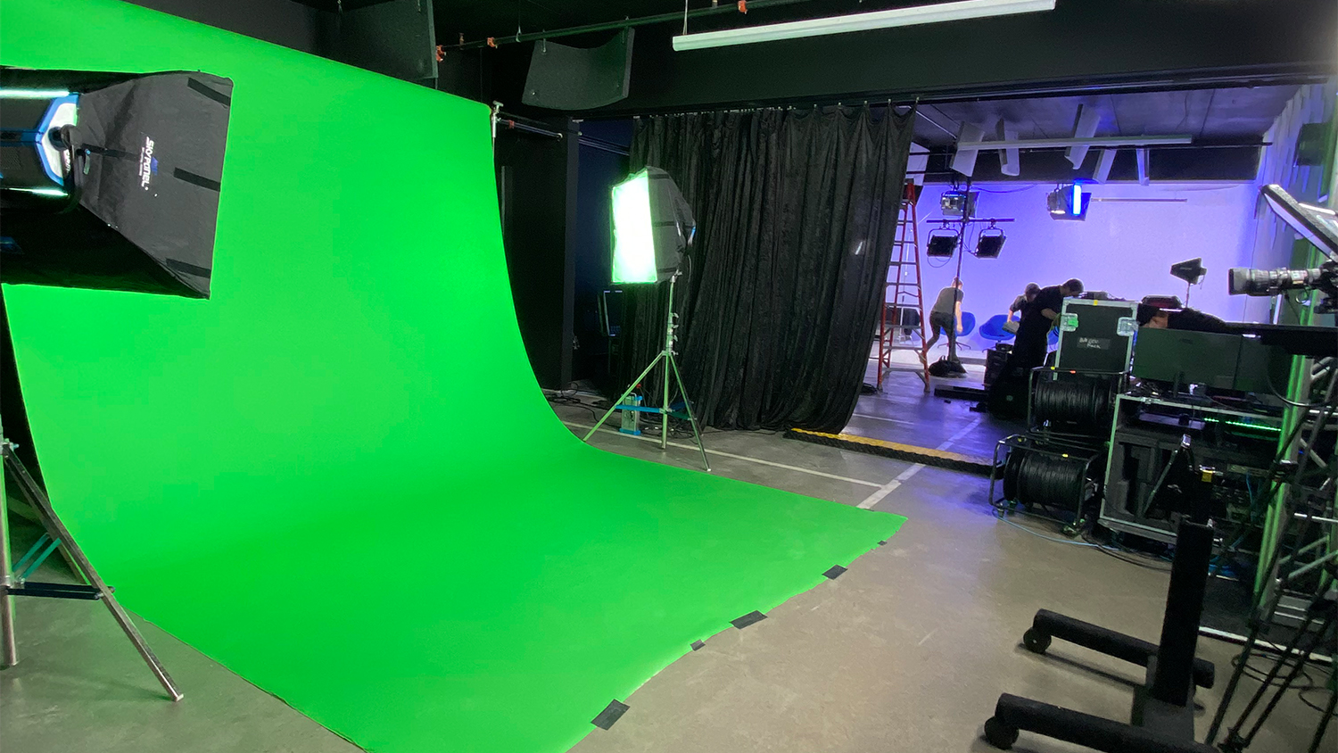 Two studios become one large rental space for large production or events. Showing green screen and cyc wall in the background combined as one open concept room.